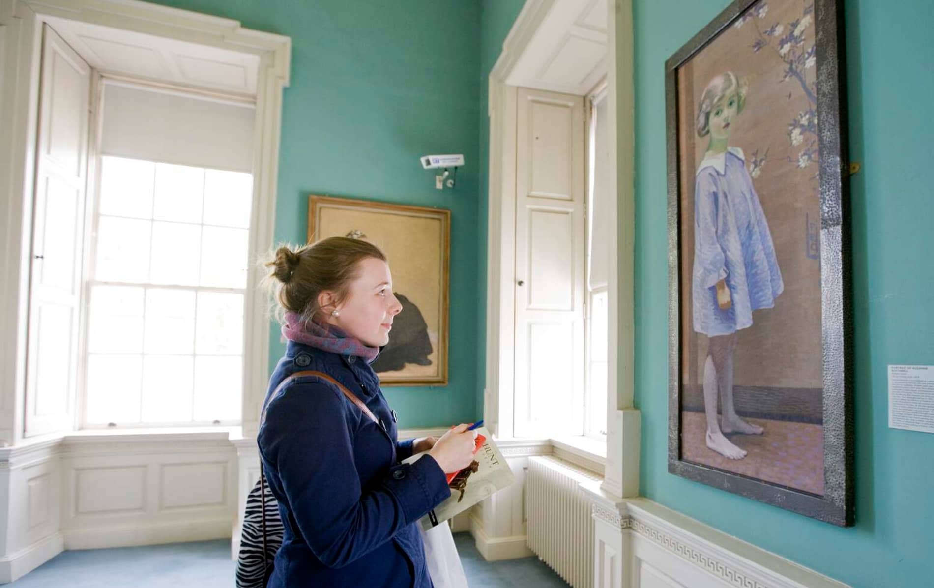 Visitor viewing a portrait in the art gallery at the Hunt Museum in Limerick.