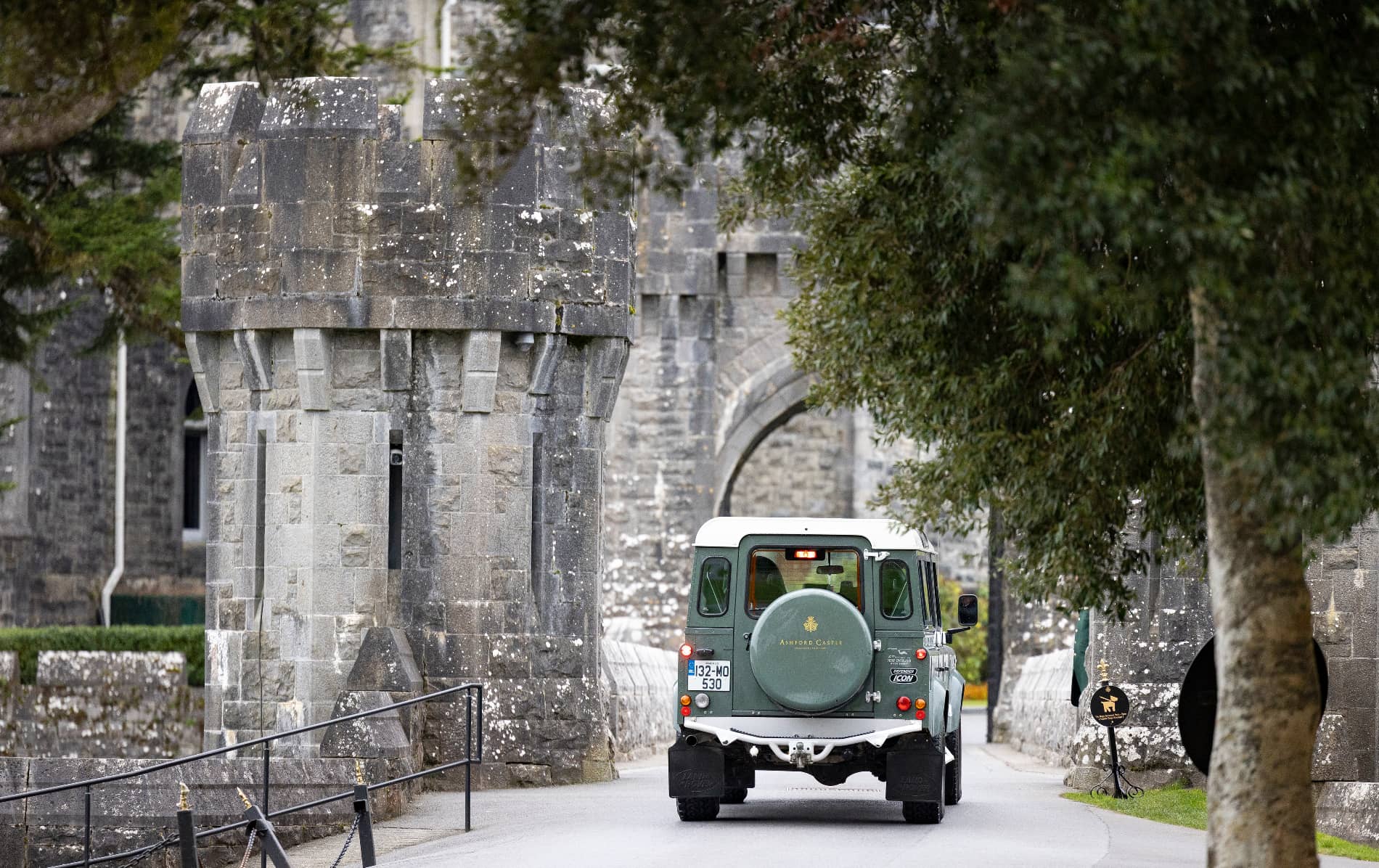 An Ashford Castle-branded jeep enters the stone gatehouse on the main driveway in County Mayo.