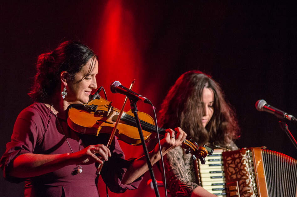 Musicians playing fiddle and accordion during a live traditional music session in Belfast's Cathedral Quarter.