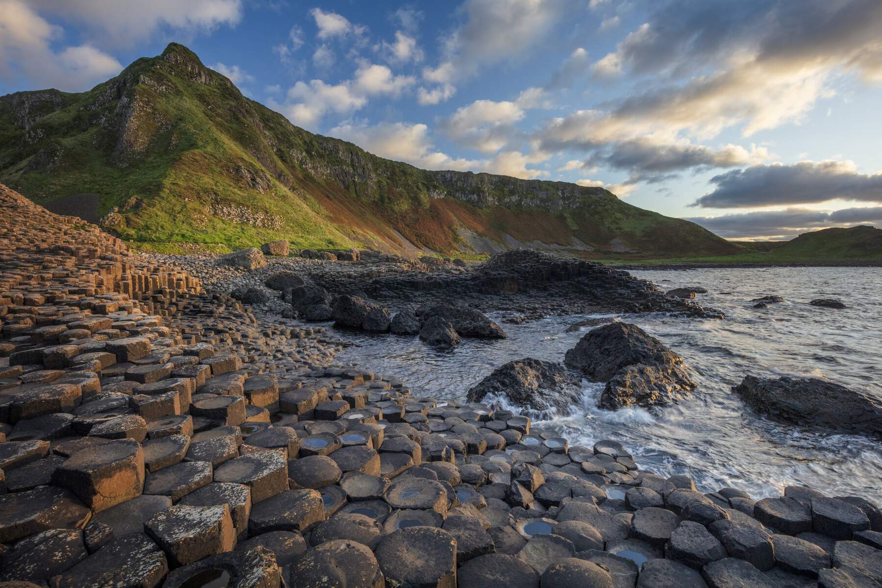 Giant’s Causeway rocks and cliffs at sunset on the Antrim Coast, Northern Ireland.