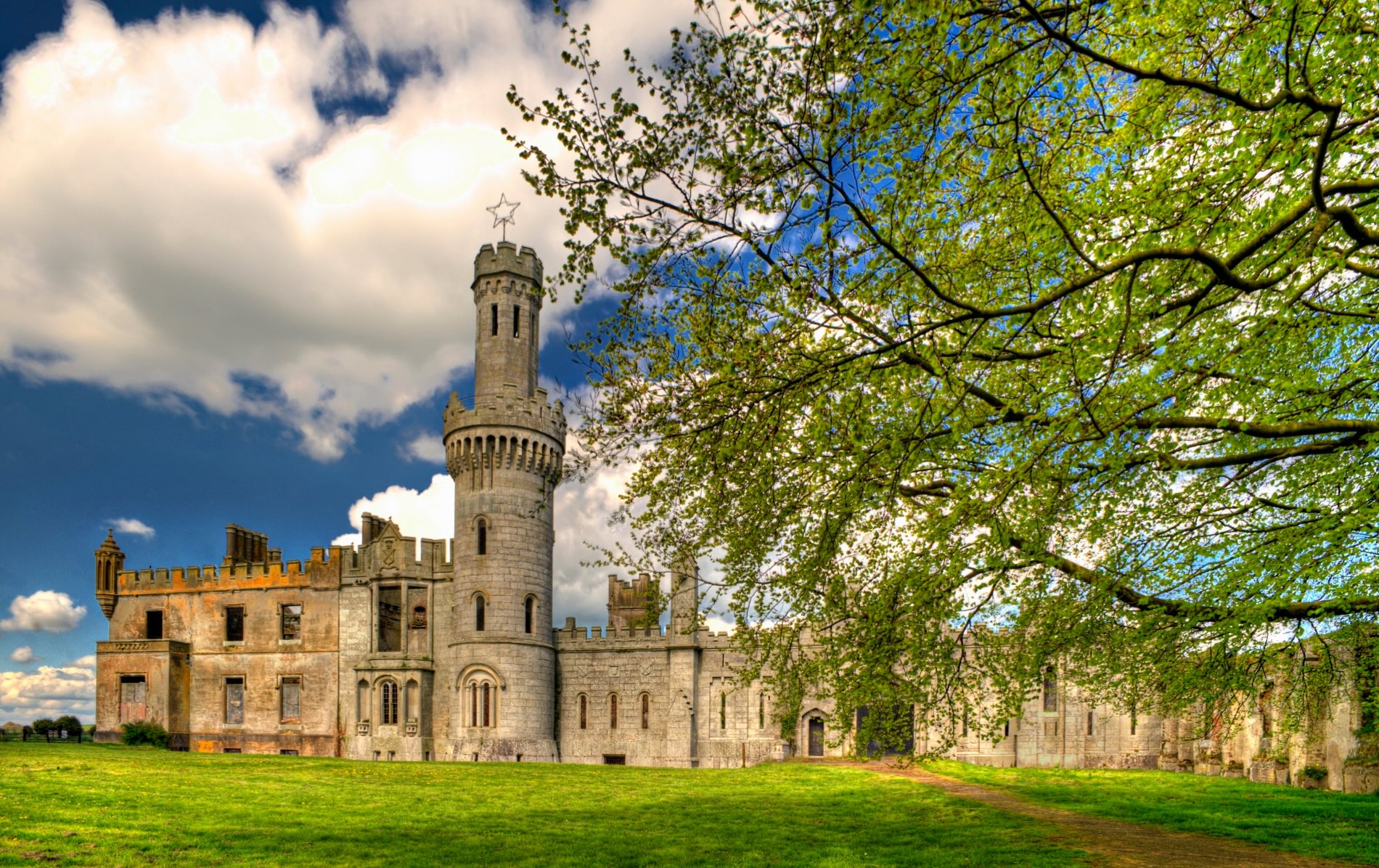 Duckett's Grove in County Carlow, framed by spring leaves against a bright blue sky.