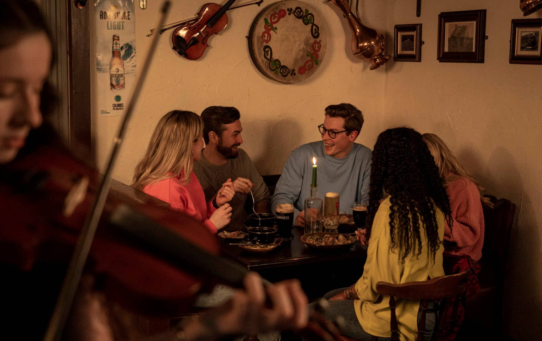 Friends enjoying food, drinks, and live traditional music in Ponderosa pub, County Londonderry, at Christmas.