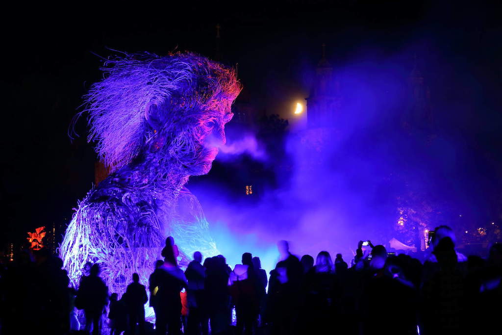 Macnas Theatre street parade in Galway city at night with crowd looking on.