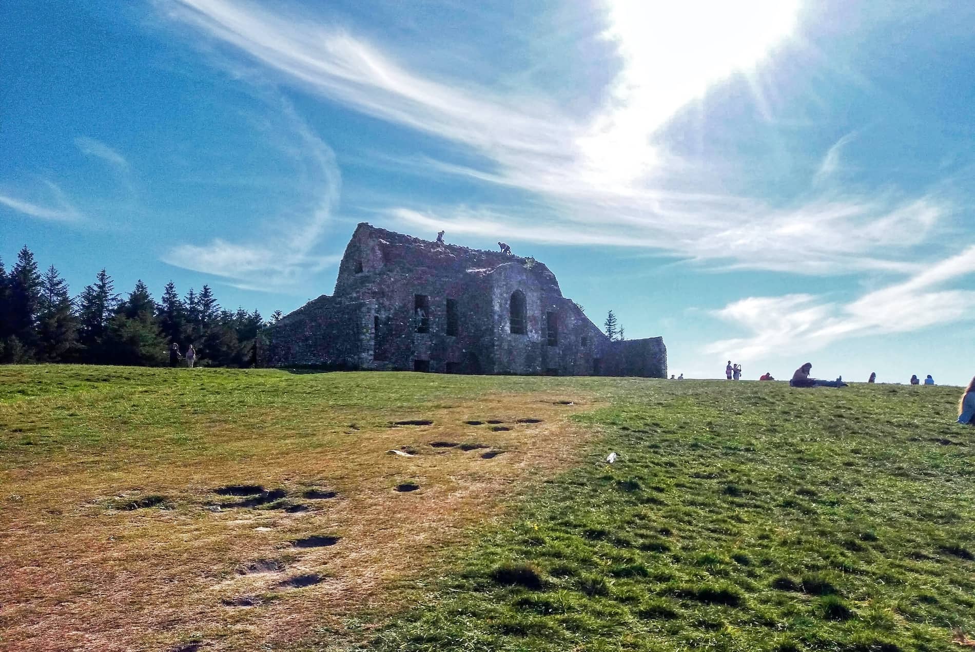 Ruins of Hell Fire Club stone lodge on Montpelier Hill, Dublin, under a bright blue sky.