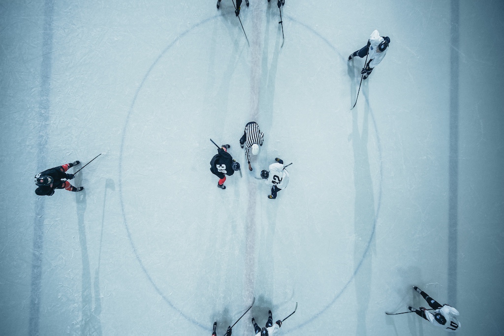 Overhead view of ice hockey players on the rink during a match.