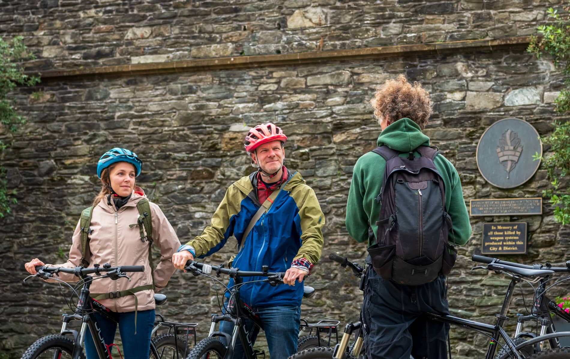 Cyclists stopping beside Derry~Londonderry’s historic city walls during a guided tour.