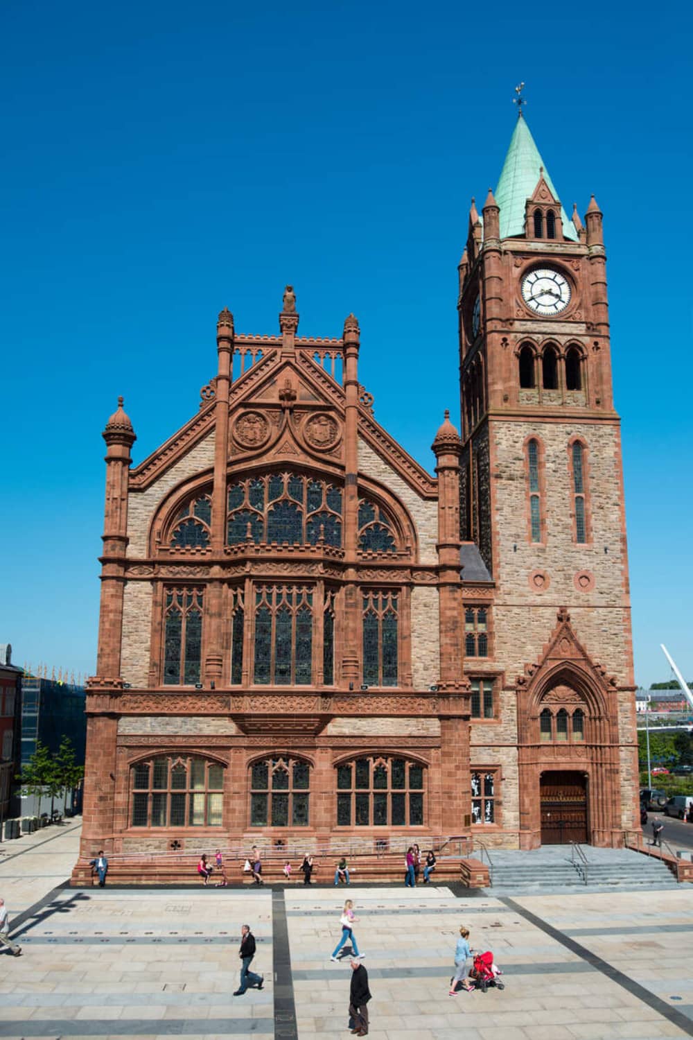 The red-brick Guildhall in Derry~Londonderry with its clock tower against a blue sky.