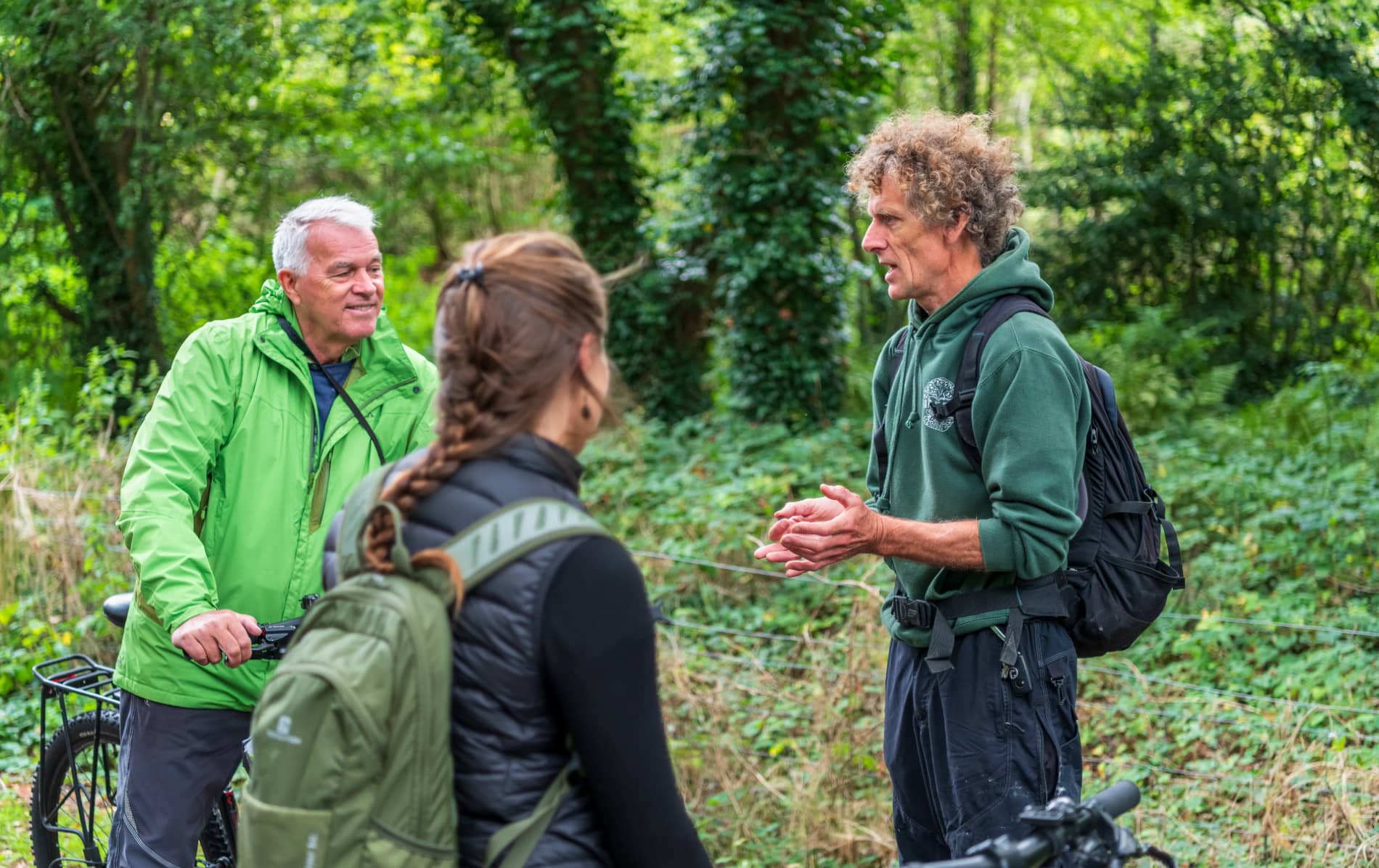 Guide speaking to cyclists during a forest stop on a Derry~Londonderry cycle tour.