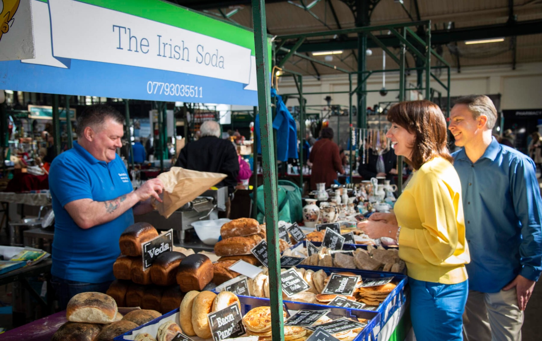 Couple buying traditional Irish bread at a market stall at St George's Market in Belfast city.
