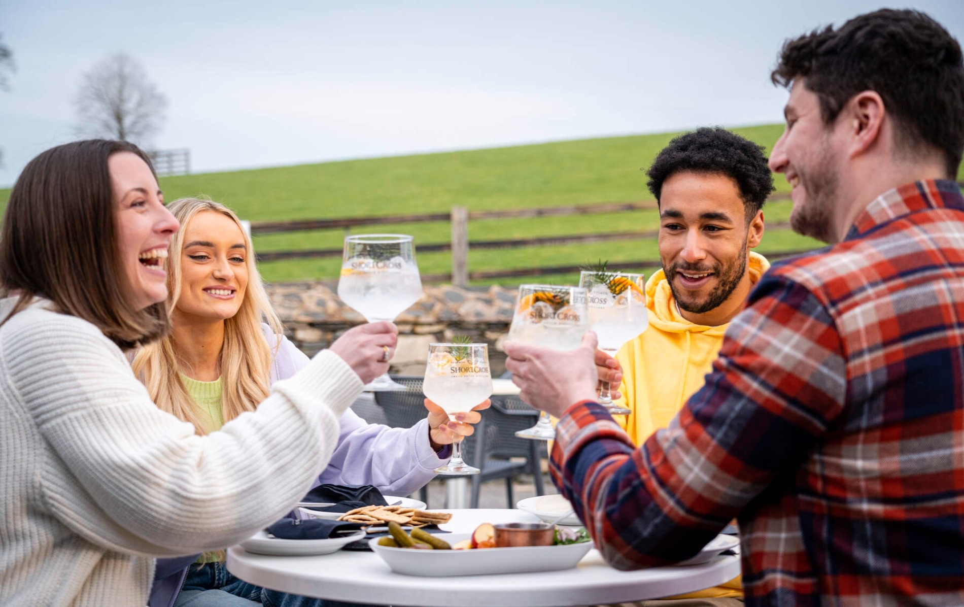 Friends enjoying Shortcross gin outdoors at Rademon Estate Distillery, County Down.