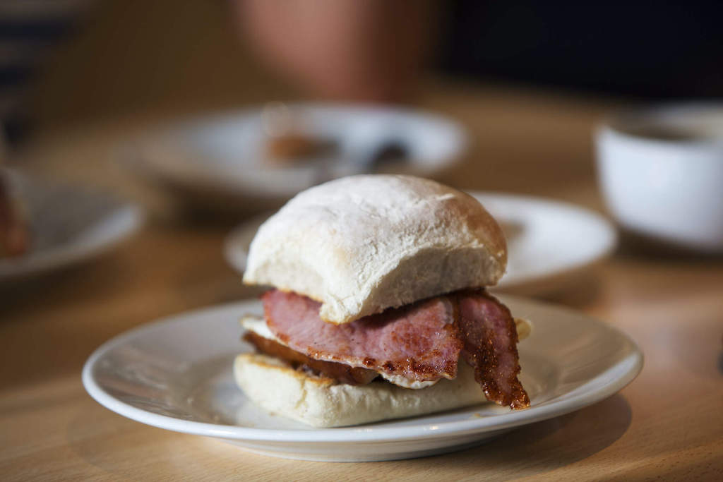 Close-up of a soft floury Waterford blaa filled with slices of grilled Irish bacon.