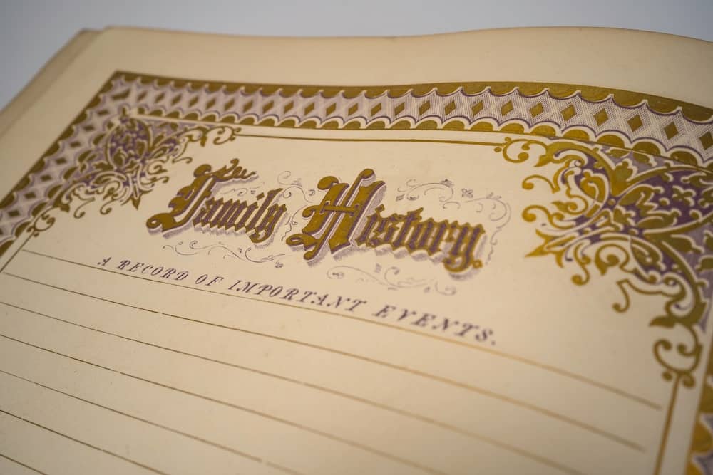 Close-up of a vintage “Family History” record book with ornate gold detailing on the cover.