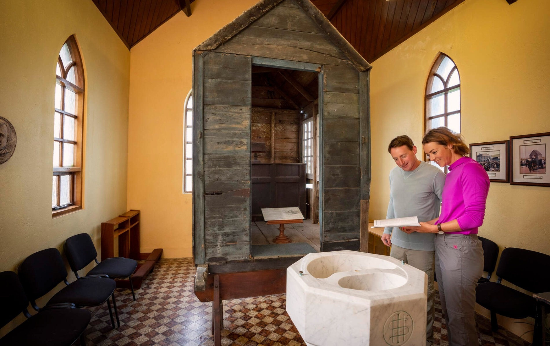 Couple reading beside The Little Ark, a mobile wooden church box used during penal times in County Clare.