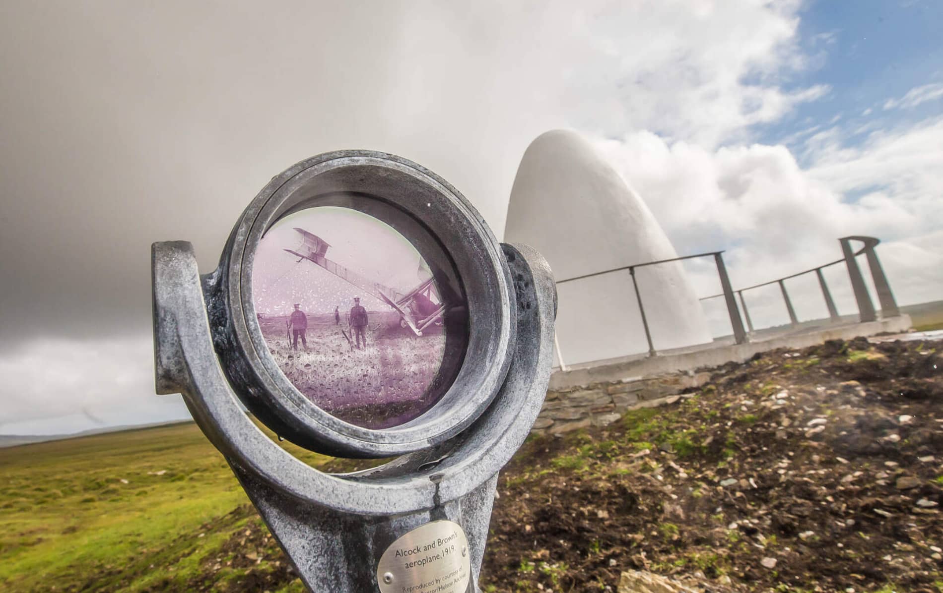 Lens view of historic Alcock and Brown plane landing photo beside the white cone memorial in County Galway.