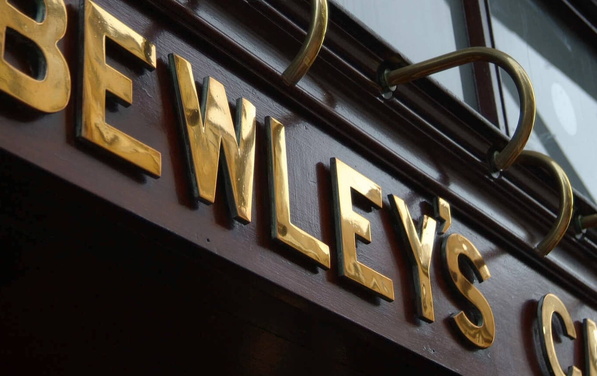 Close-up of the gold-lettered Bewley’s Café sign gleaming against dark wood outside the iconic Dublin café on Grafton Street.