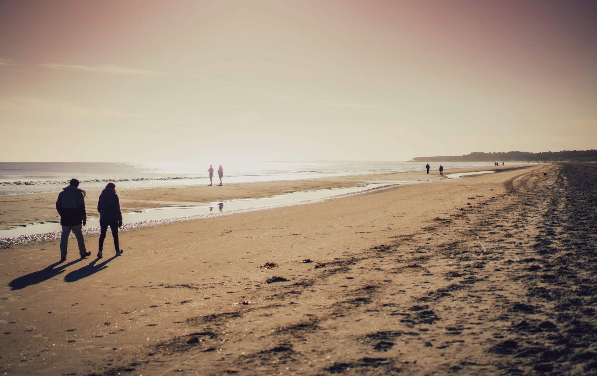 Walkers enjoy Sandymount Strand in Dublin, a setting evoked in the writings of Irish novelist Colm Tóibín.