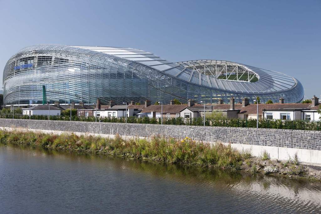 Aviva Stadium’s glass exterior reflecting blue skies beside the River Dodder in Dublin’s Ballsbridge neighbourhood.