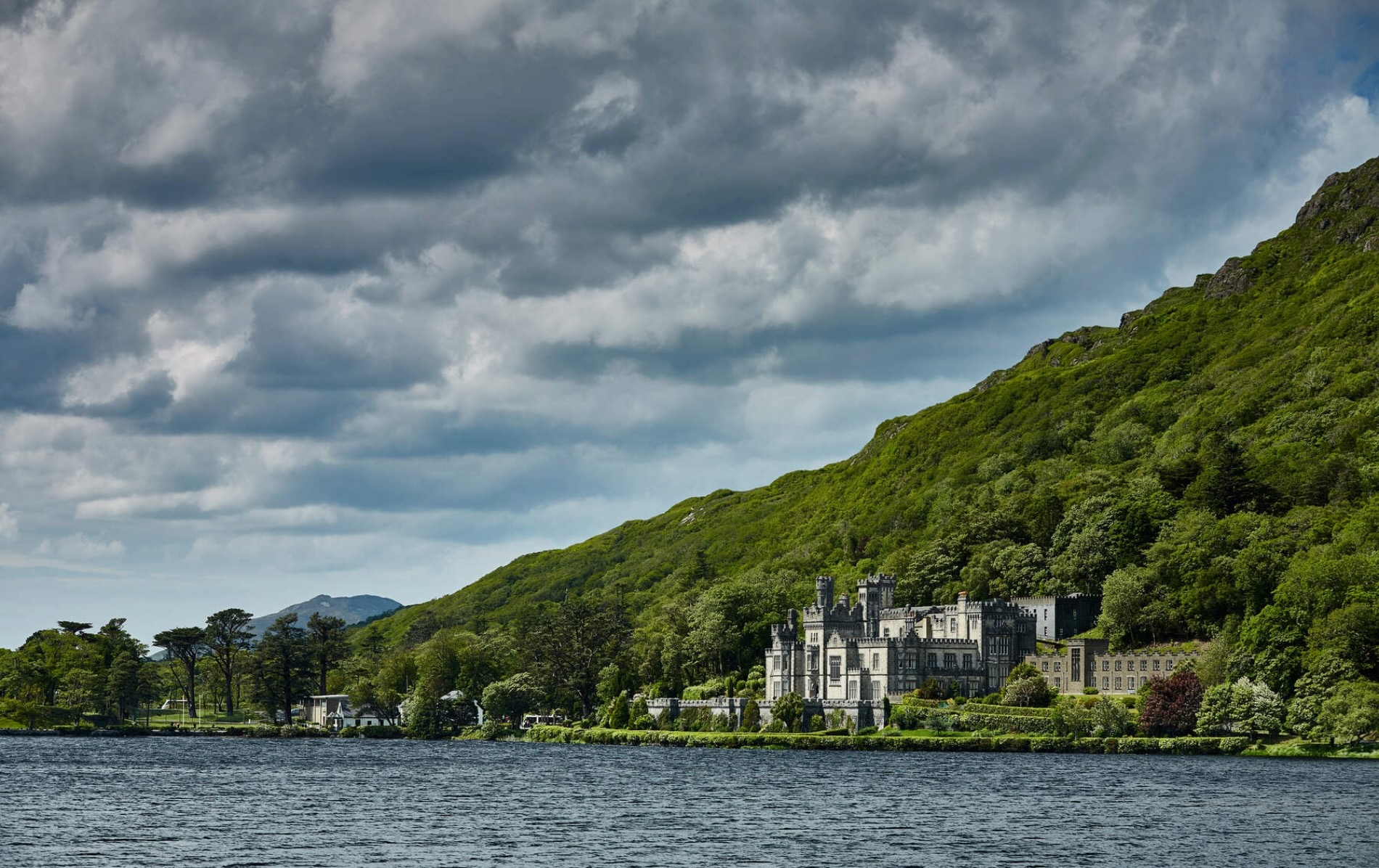 Kylemore Abbey nestled at the foot of a wooded hill beside Pollacapall Lough in County Galway.