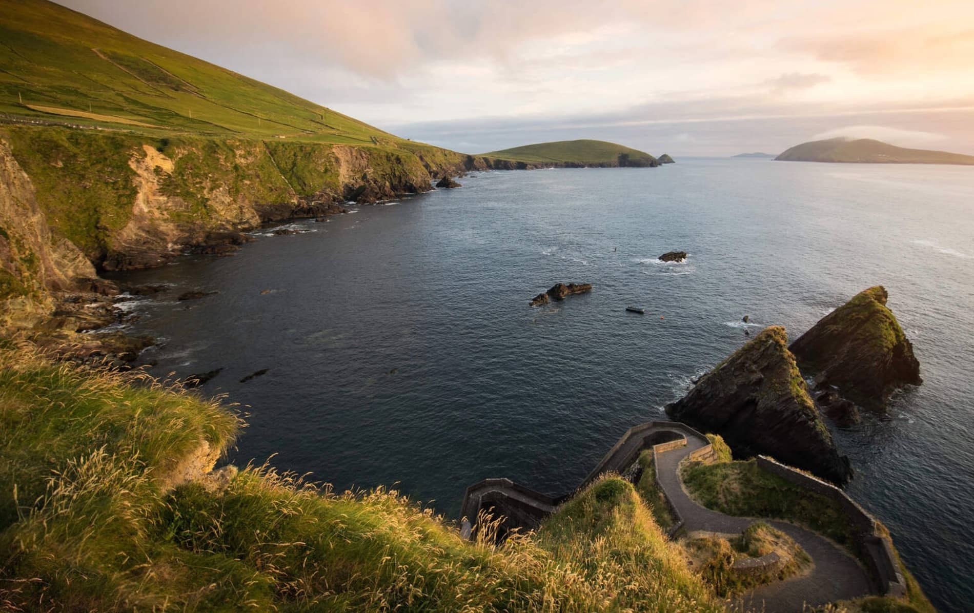 The iconic zigzag path at Dunquin Harbour, Kerry, descends dramatically to the sea with views of rugged cliffs and rocky islands.