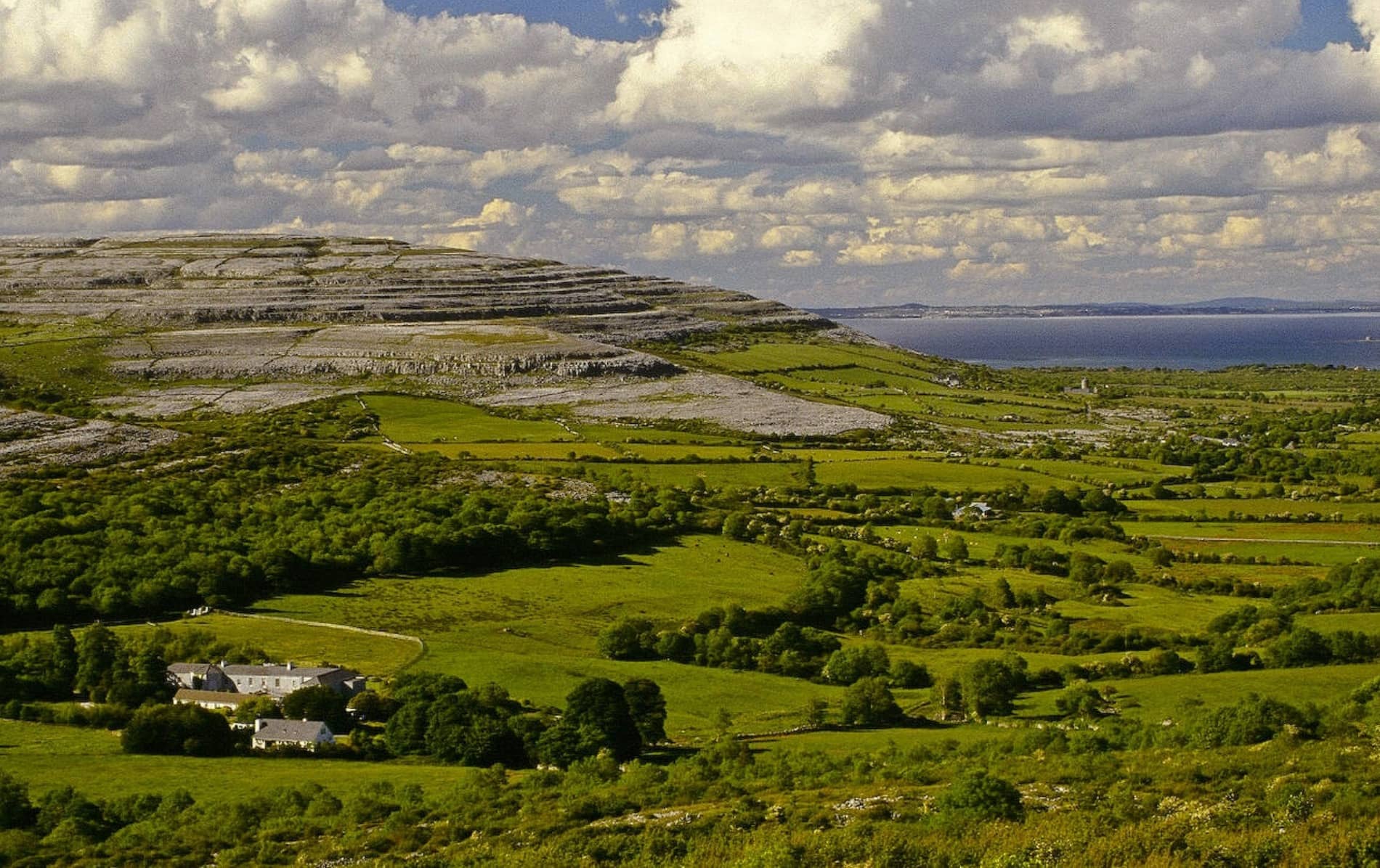 The unique rocky limestone landscape of the Burren, County Clare, stretches into the distance, dotted with green fields.