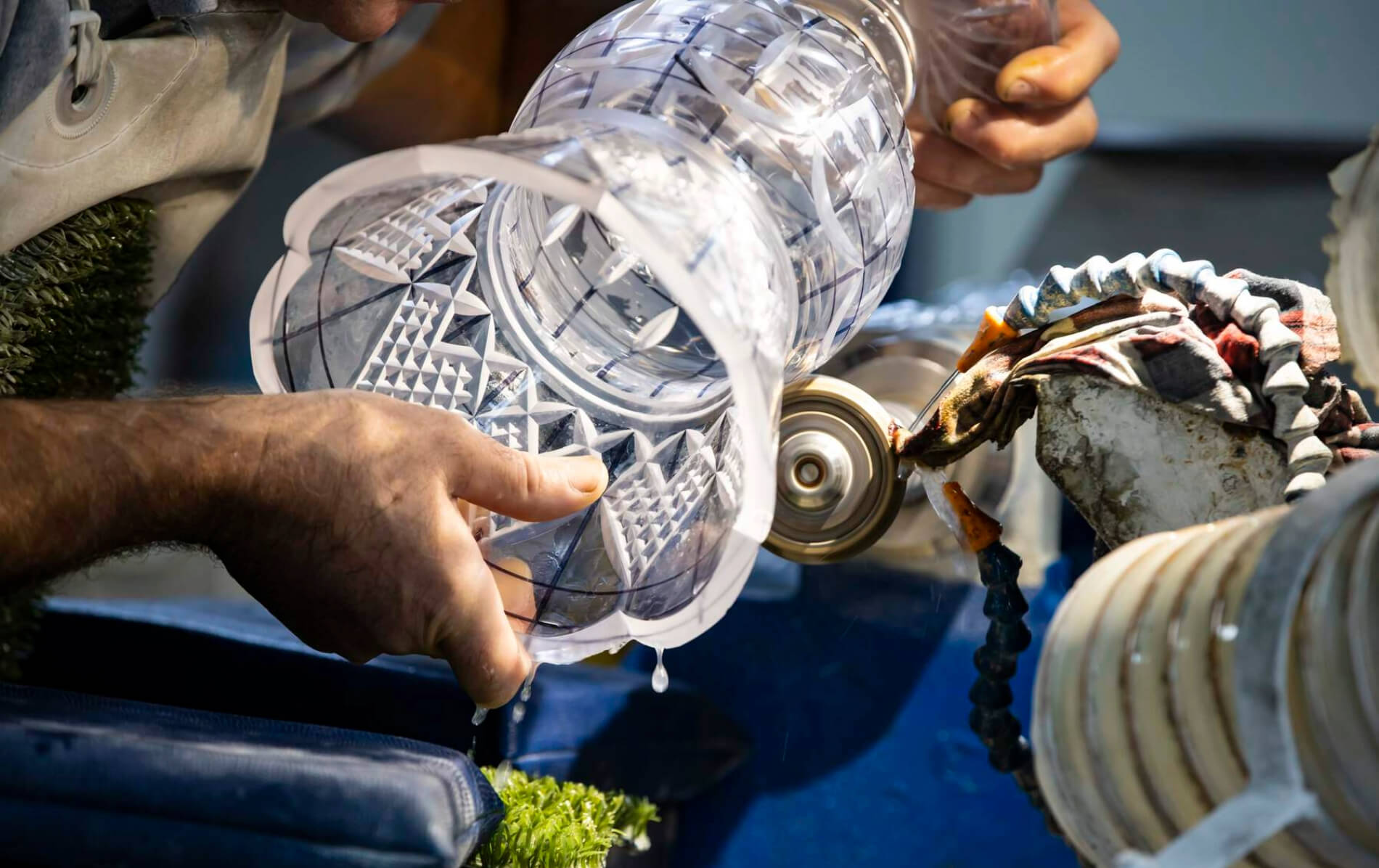 A craftsman cuts intricate patterns into a glass vase at the House of Waterford Crystal.