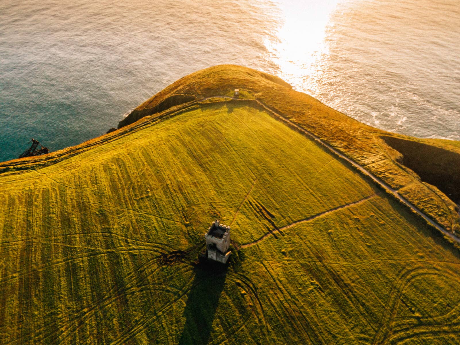 Sunset over a grassy headland and small tower on St Declan’s Way overlooking the Atlantic.