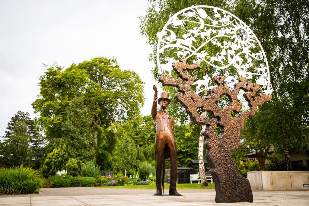Bronze statue of a man in a top hat beside an artistic sculpture at the Irish National Stud in County Kildare.