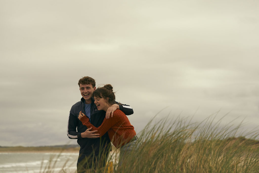 Marianne and Connell laugh together on a windswept Sligo beach.