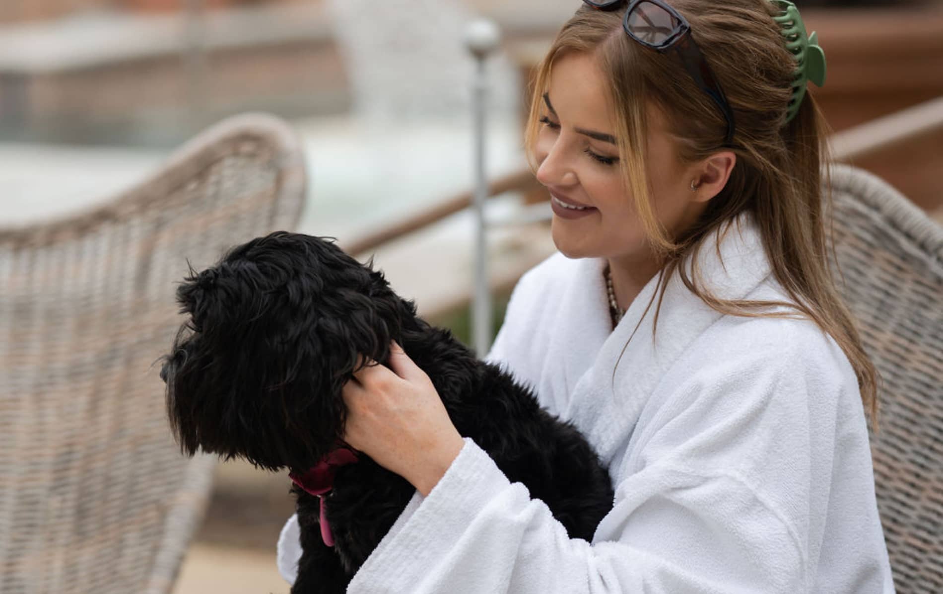 Woman in white robe holding a small black dog at The Rabbit Hotel in County Antrim.
