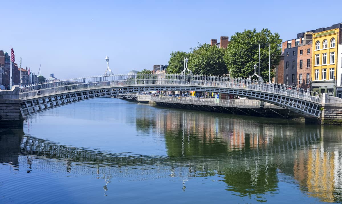 The Ha’penny Bridge spanning the River Liffey on a bright day in Dublin city centre.