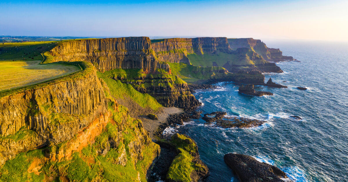 Basalt cliffs on the Causeway Coast in County Antrim above the Atlantic Ocean at golden hour.