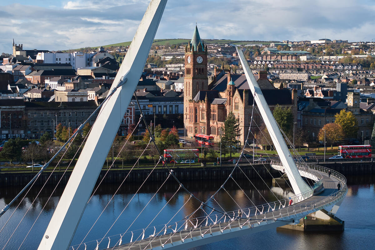Derry~Londonderry skyline framed by the Peace Bridge crossing the River Foyle.