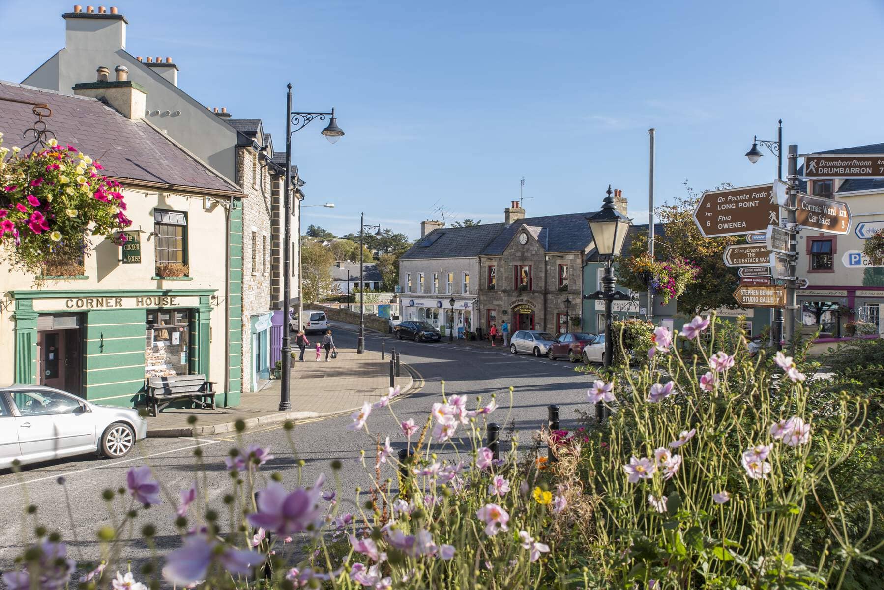 Charming street scene in Ardara, County Donegal, with hanging flower baskets and traditional Irish shopfronts.