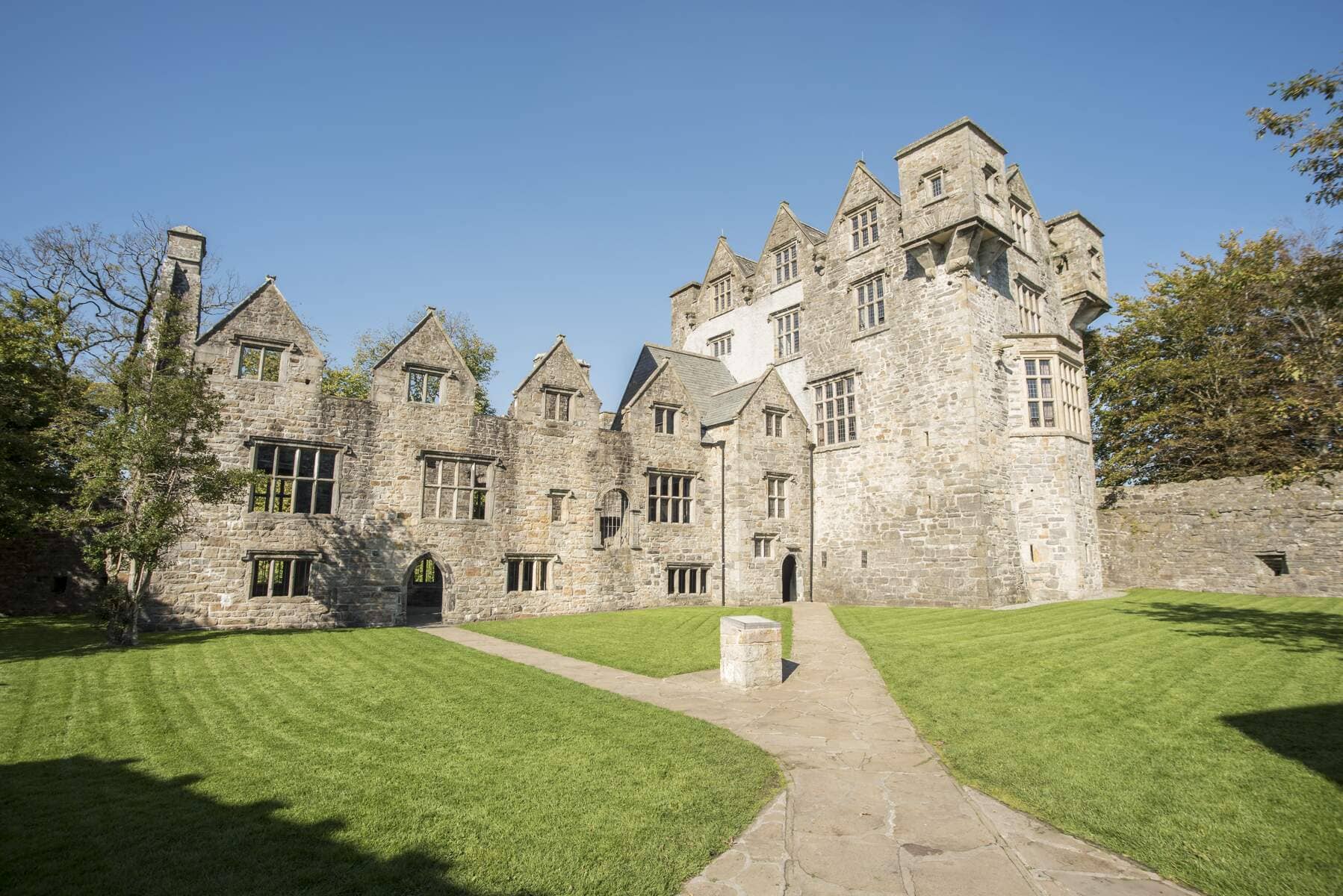 Historic Donegal Castle in the heart of Donegal town, surrounded by manicured lawns on a bright, clear day.