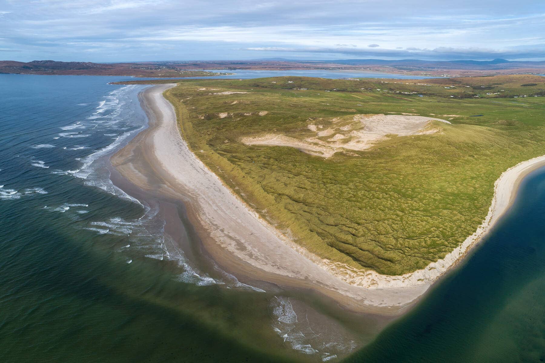 Aerial view of Dooey Beach in Lettermacaward, County Donegal, with golden sands and wild grassy dunes.