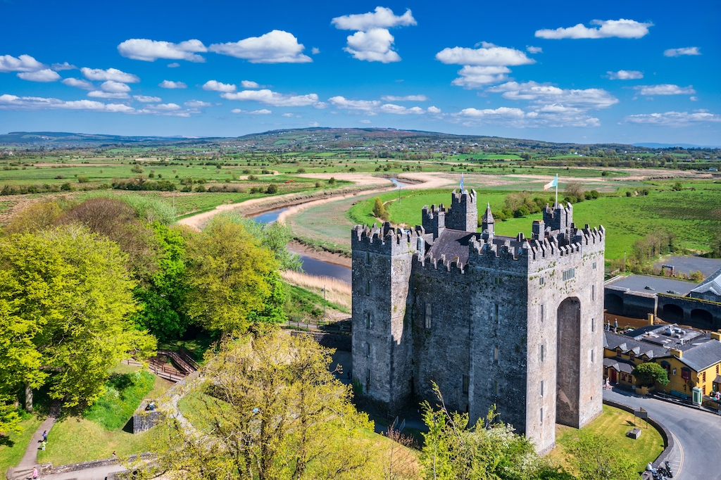 Bunratty Castle beside the River Ratty in County Clare, surrounded by green countryside.