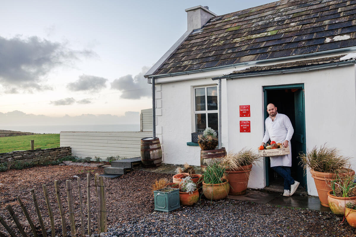 Chef carrying fresh local produce outside Homestead Cottage in County Clare.