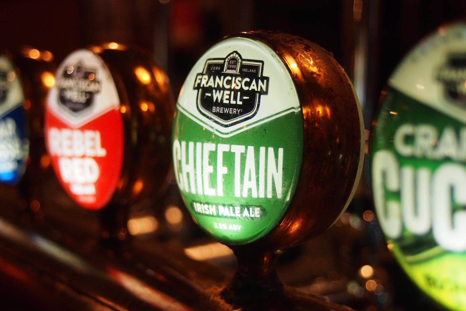 Close-up of beer taps at Franciscan Well Brewery in Cork city, featuring a Chieftain ale label.