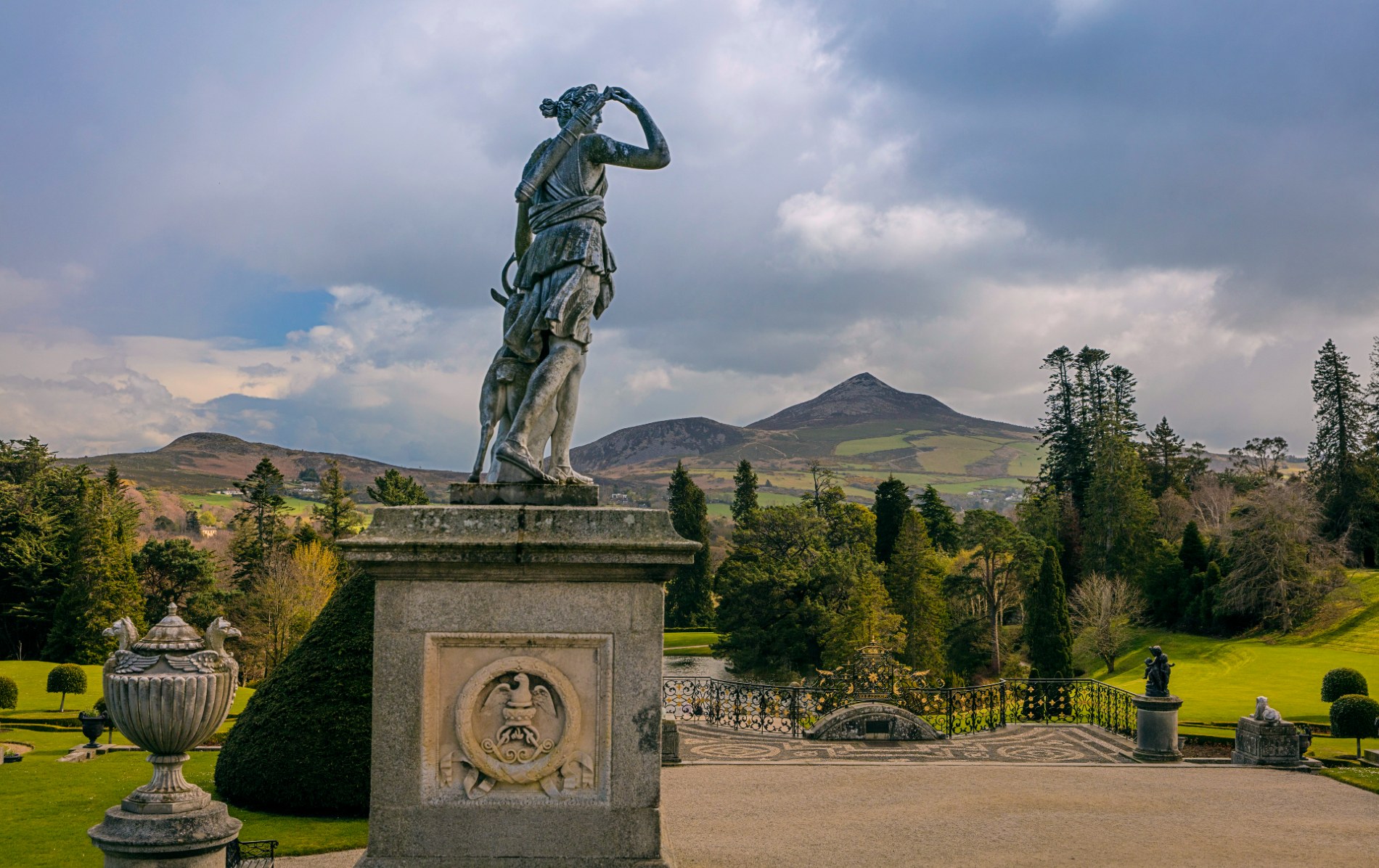 Statue of Diana the Huntress at Powerscourt Estate in County Wicklow, overlooking manicured gardens and Sugarloaf Mountain.