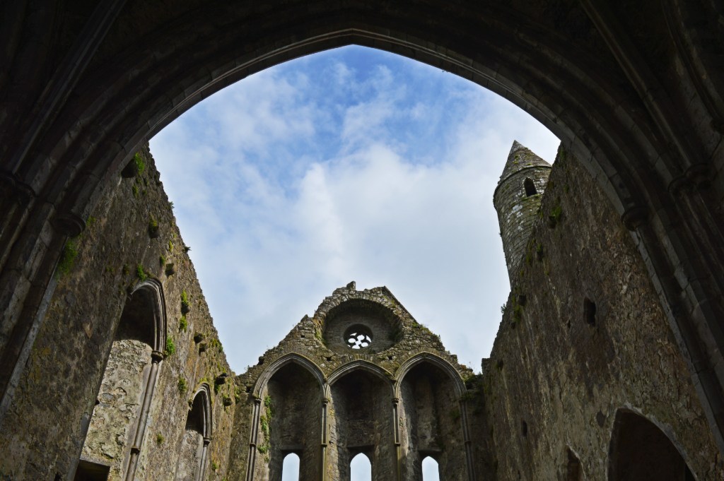 View through a stone archway to the ruins of a medieval church at the Rock of Cashel.