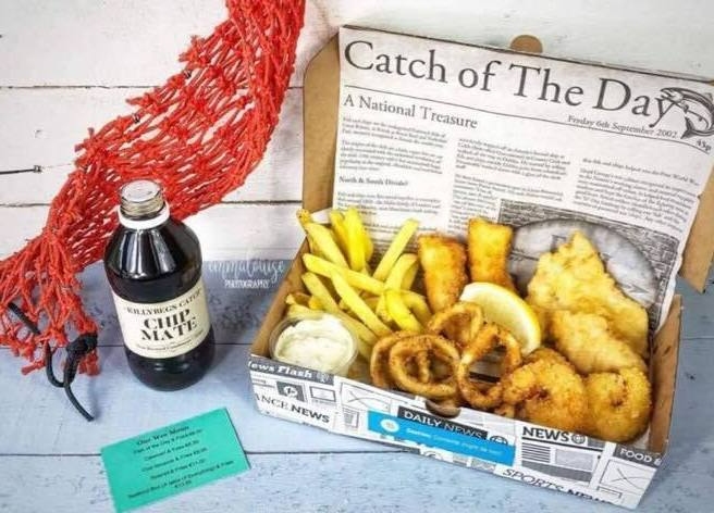 Seafood box from Killybegs Seafood Shack, County Donegal, with fish, chips, onion rings, and tartar sauce.