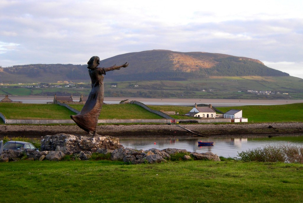 Bronze 'Waiting on Shore' sculpture overlooks the sea in Rosses Point, County Sligo, with Knocknarea in the background.