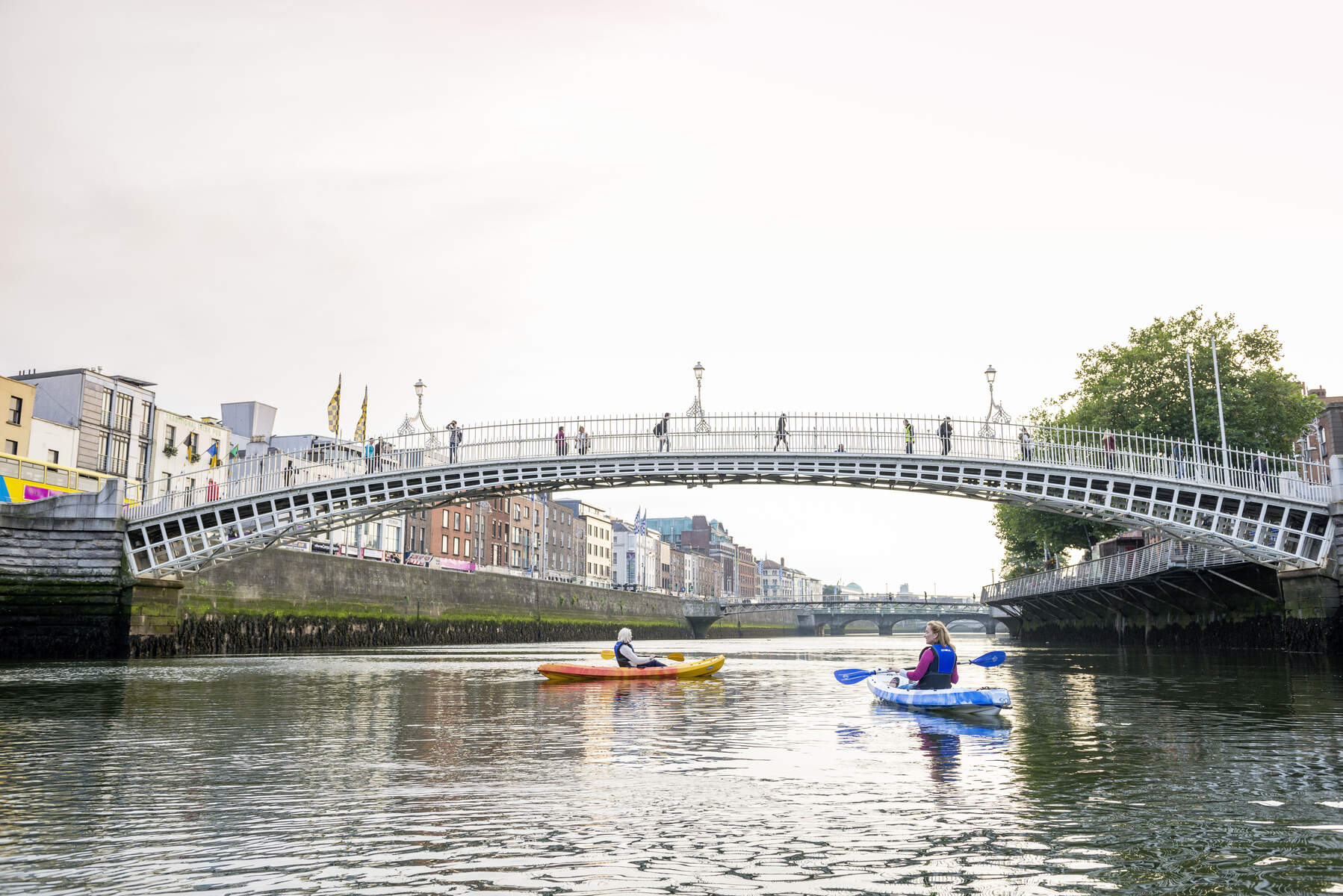 People kayaking under the Ha’penny Bridge on Dublin’s River Liffey.
