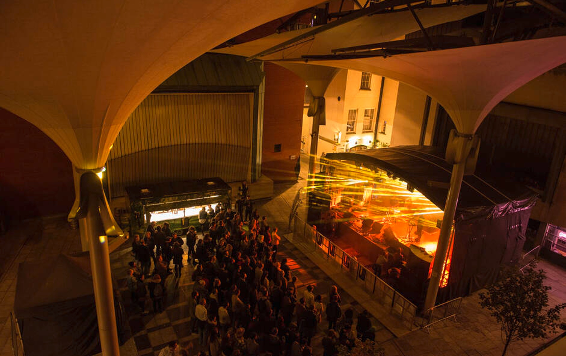 Crowd gathered at an outdoor music stage with dramatic lighting at Meeting House Square, Temple Bar.
