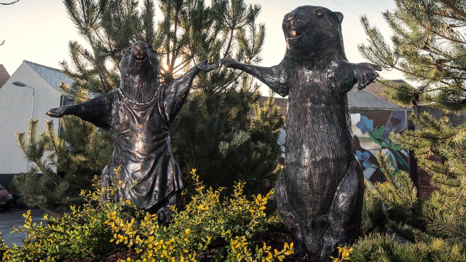 Bronze beaver statues holding hands in landscaped gardens at CS Lewis Square, Belfast.