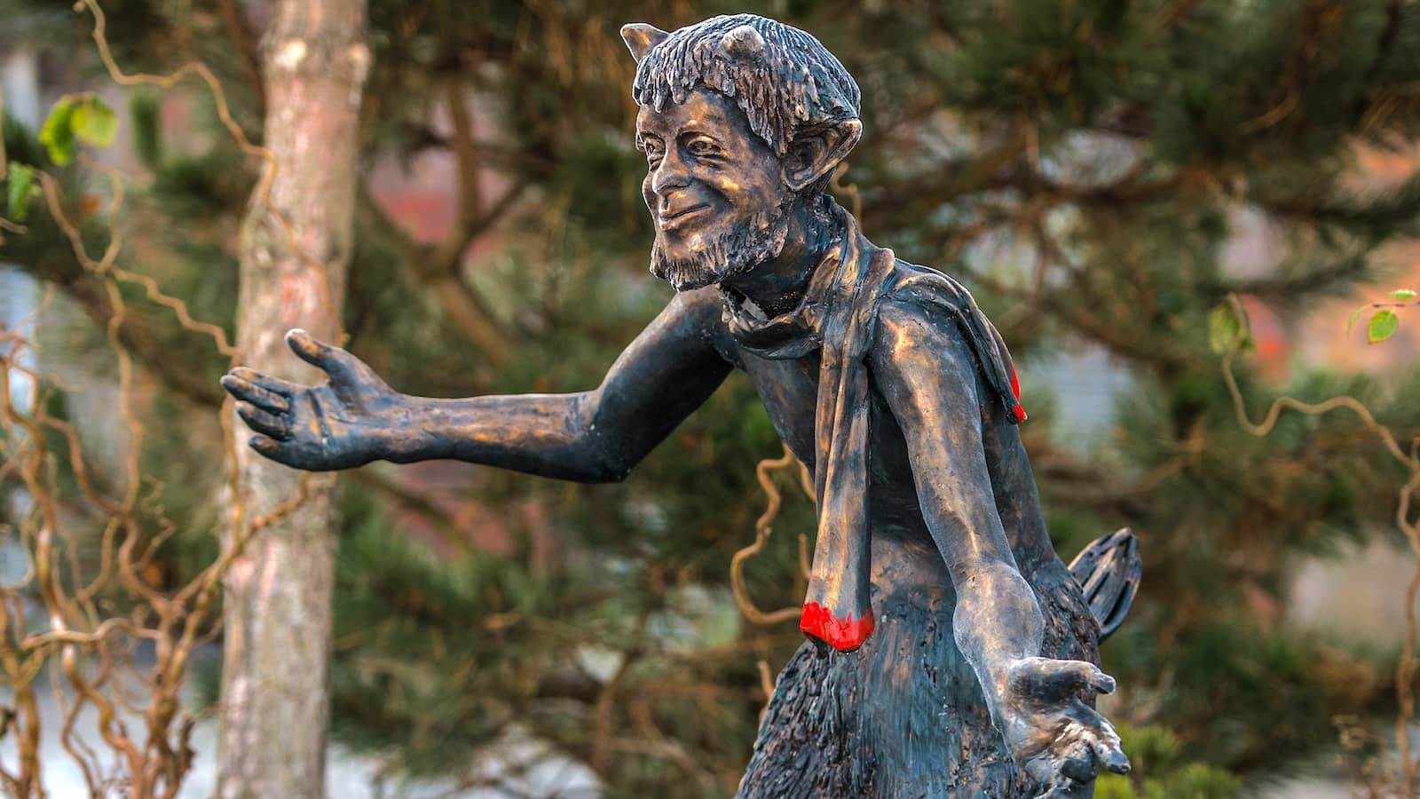 Bronze statue of Mr Tumnus the faun reaching forward in gardens at CS Lewis Square, Belfast.