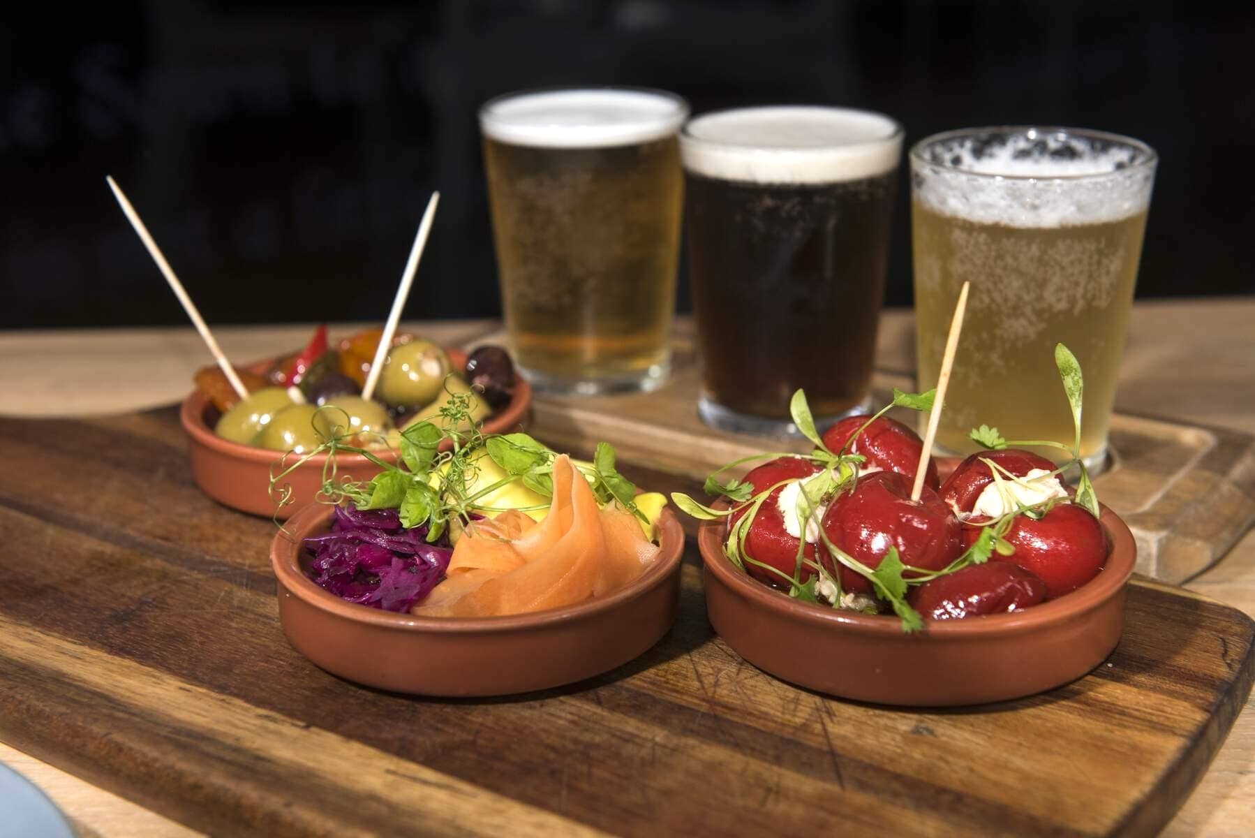 Tapas dishes with olives, peppers and salad served with glasses of beer at the Walled City Brewery, Derry~Londonderry.