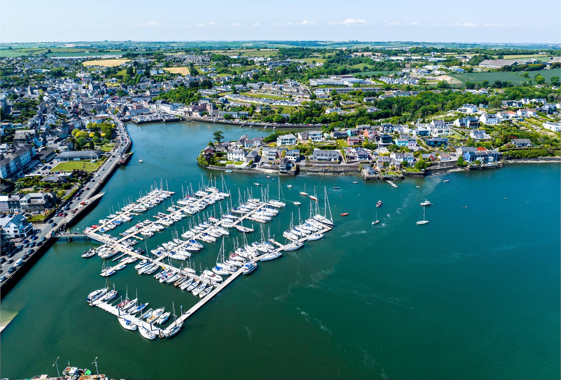 Aerial view of Kinsale Harbour and marina in County Cork, with yachts and colourful waterfront buildings.