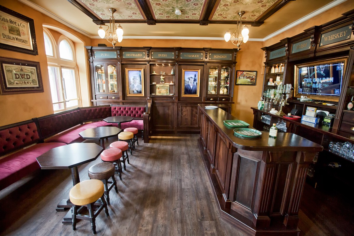 Interior of the Irish Whiskey Museum in Dublin featuring a traditional bar, vintage stools, and whiskey memorabilia.