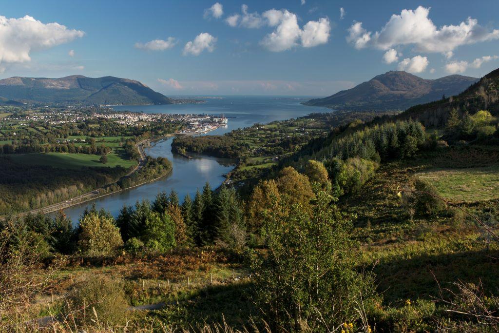 Panoramic view of Newry and Carlingford Lough surrounded by rolling hills and mountains.